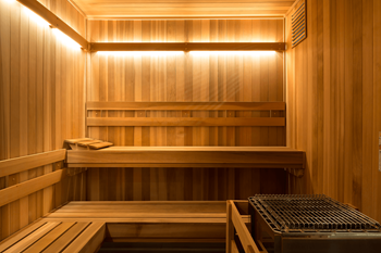 A wooden sauna with a bench and a heater.